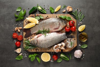 Photo of Fresh raw crucian carps and ingredients on grey table, flat lay. River fish
