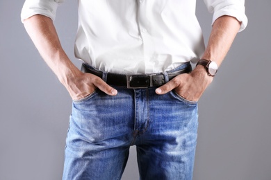 Photo of Man in stylish blue jeans on grey background