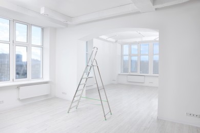 Photo of Light spacious room with step ladder. Ceiling painting