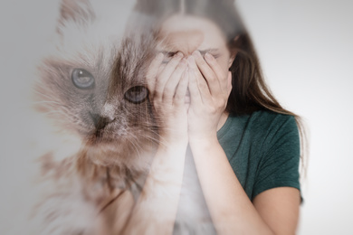Image of Woman suffering from ailurophobia on white background. Irrational fear of cats