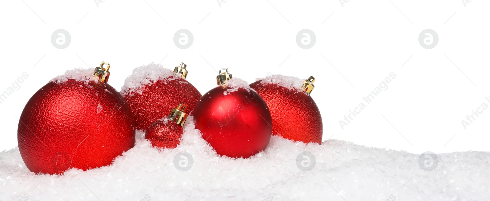 Photo of Beautiful red Christmas balls on snow against white background