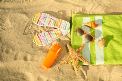 Photo of Flat lay composition with stylish beach accessories on sand