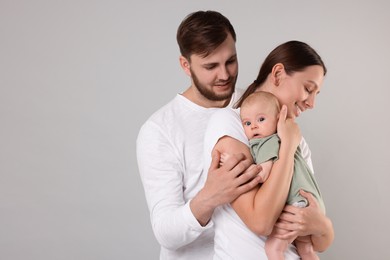 Happy family. Parents with their cute baby on grey background, space for text