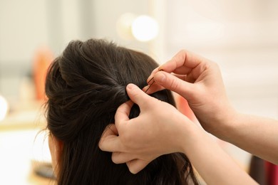 Hair styling. Professional hairdresser working with client indoors, closeup