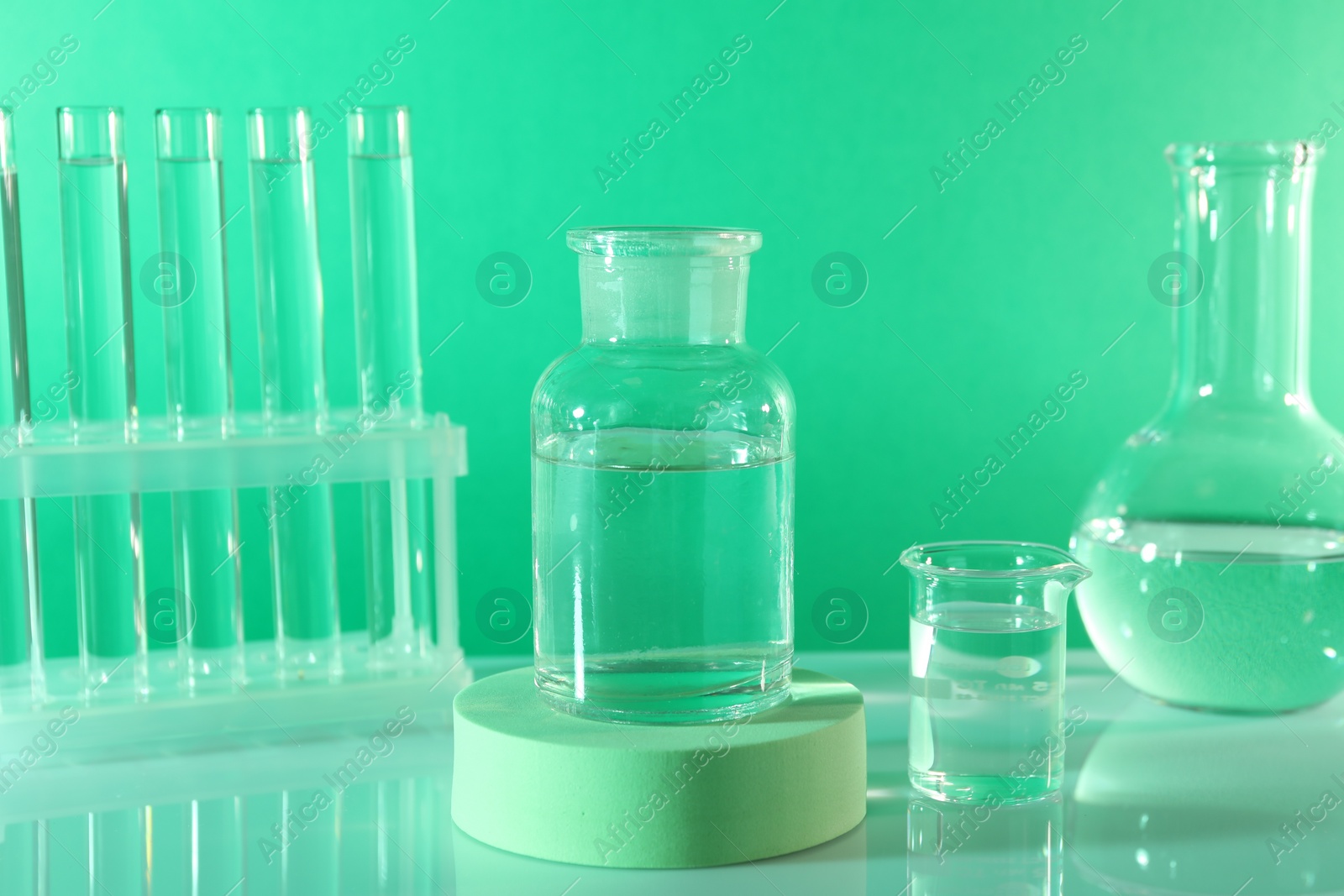 Photo of Laboratory analysis. Different glassware on table against green background