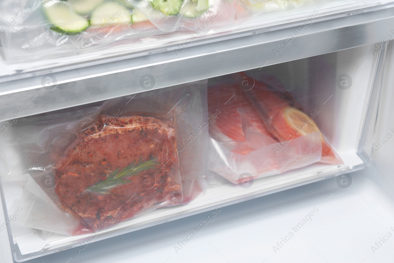 Photo of Vacuum bags with different products in fridge. Food storage