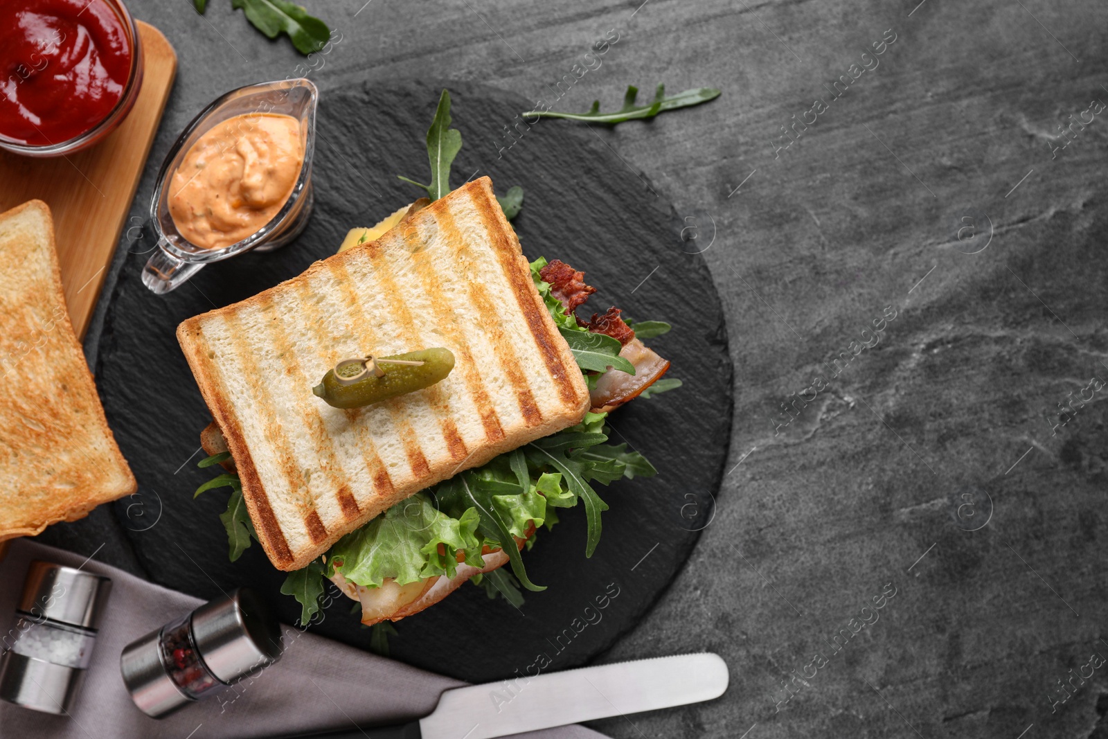 Photo of Tasty sandwich with toasted bread served on grey table, flat lay. Space for text