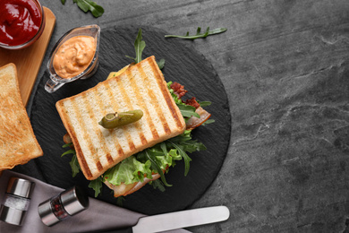 Photo of Tasty sandwich with toasted bread served on grey table, flat lay. Space for text