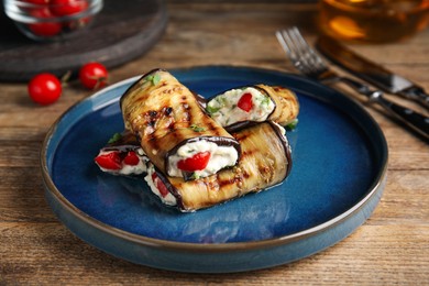 Delicious baked eggplant rolls served on wooden table