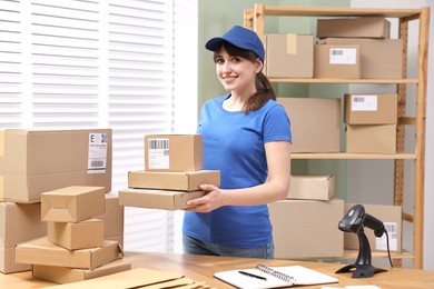 Parcel packing. Post office worker with parcels at wooden table indoors