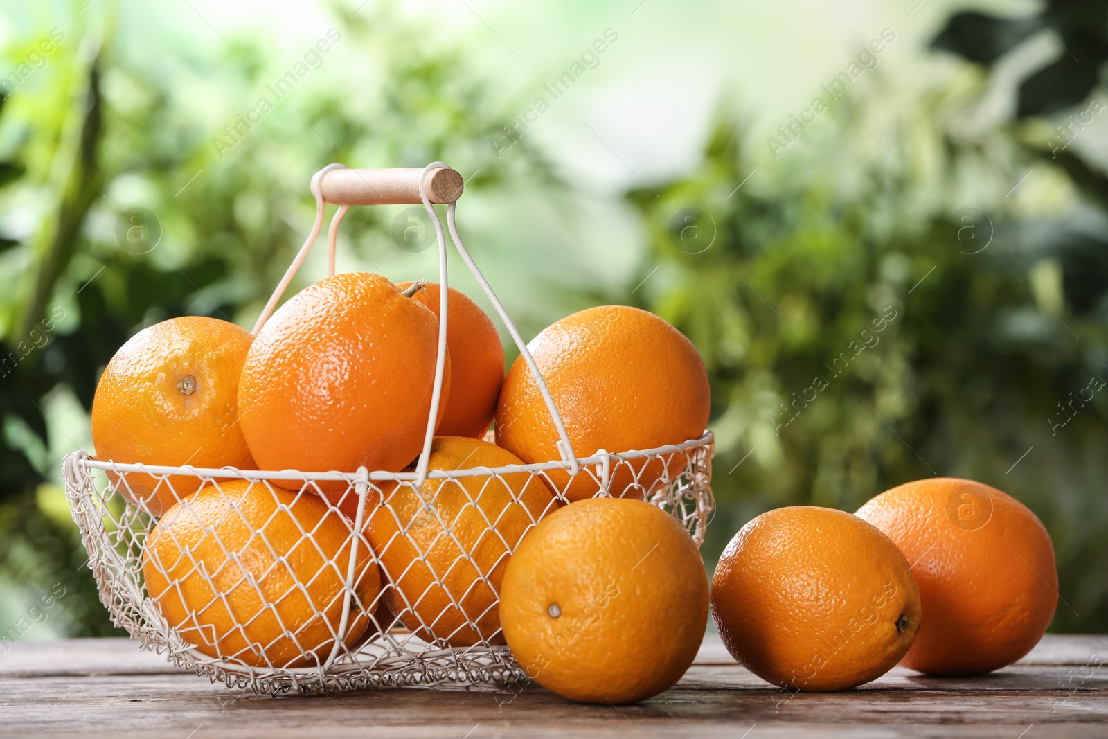 Photo of Basket and fresh oranges on wooden table. Space for text