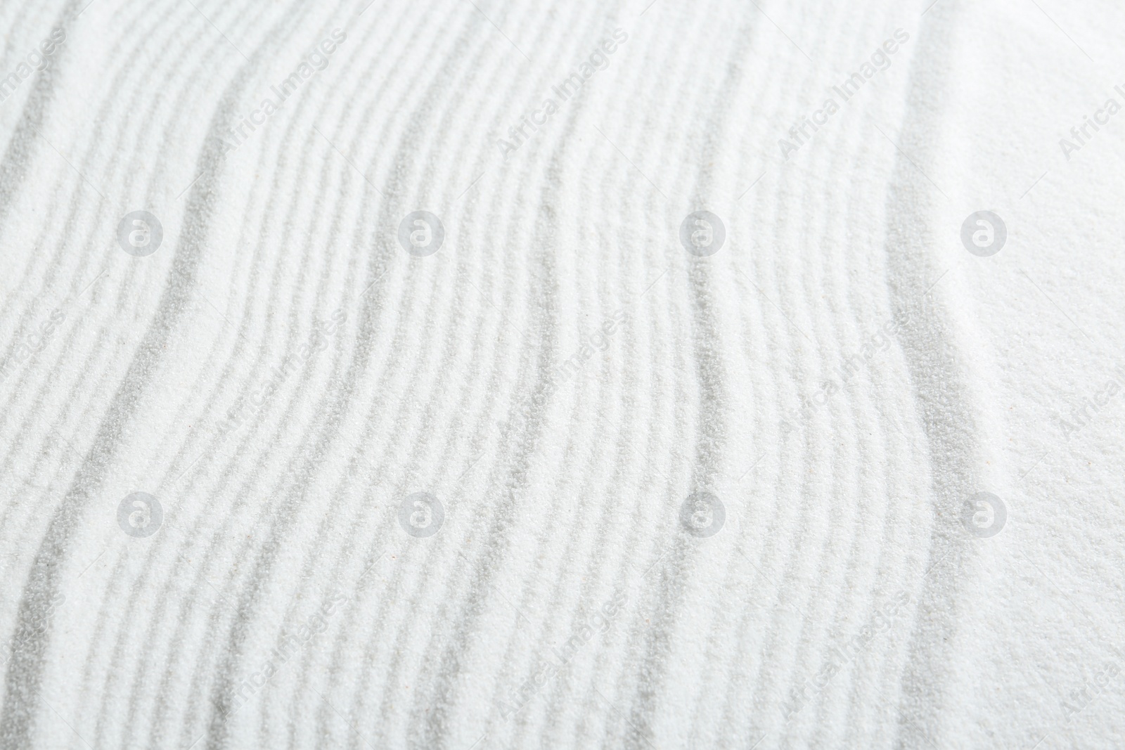 Photo of Zen rock garden. Wave pattern on white sand, closeup