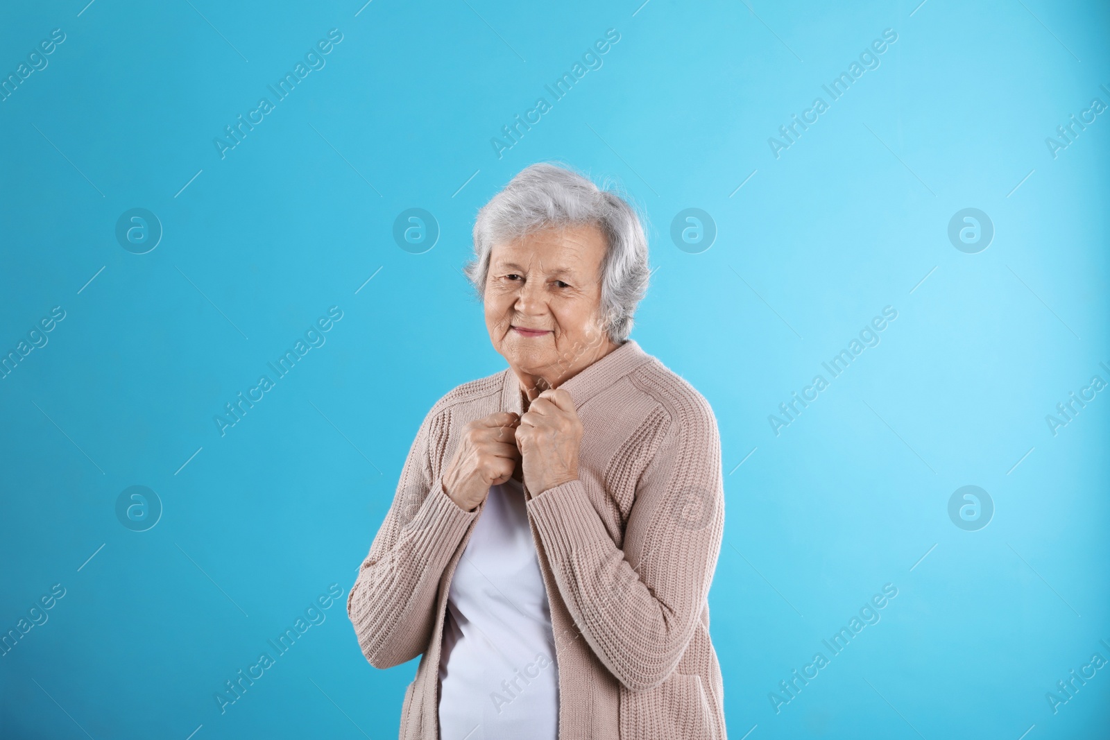 Photo of Portrait of grandmother in stylish clothes on color background
