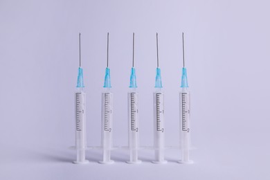 Photo of Disposable syringes with needles on white background