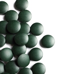 Photo of Spirulina tablets on white background, top view