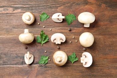 Photo of Flat lay composition with fresh champignon mushrooms on wooden background