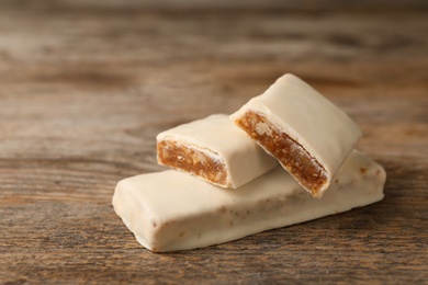 Photo of Tasty protein bars on wooden table. Space for text