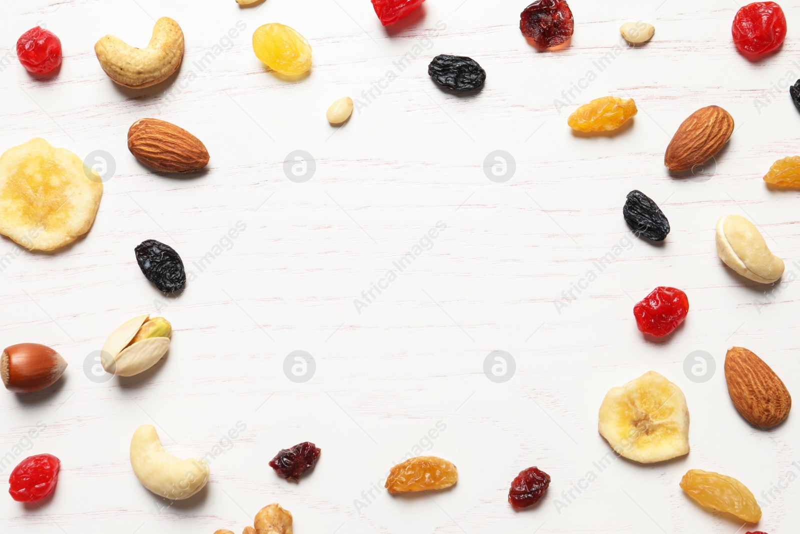 Photo of Flat lay composition of different dried fruits and nuts on wooden background. Space for text