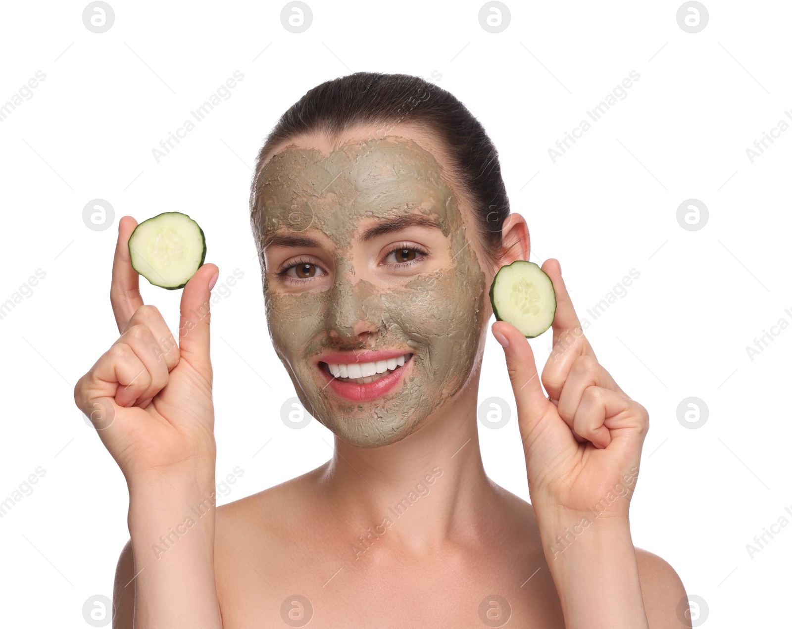 Photo of Beautiful woman with clay mask holding pieces of cucumber on white background