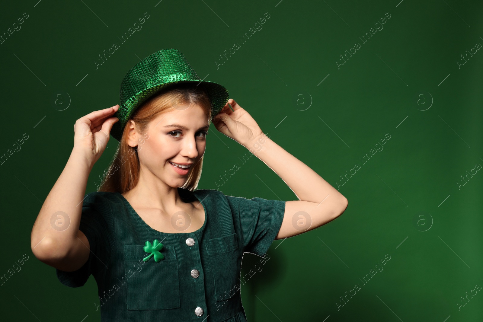 Photo of Young woman in green outfit on color background. St. Patrick's Day celebration