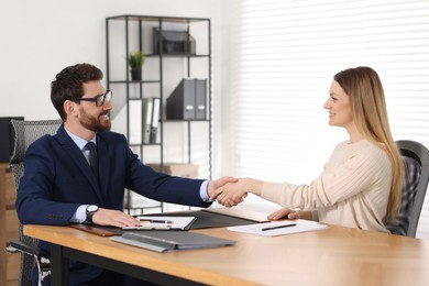 Lawyer shaking hands with client in office