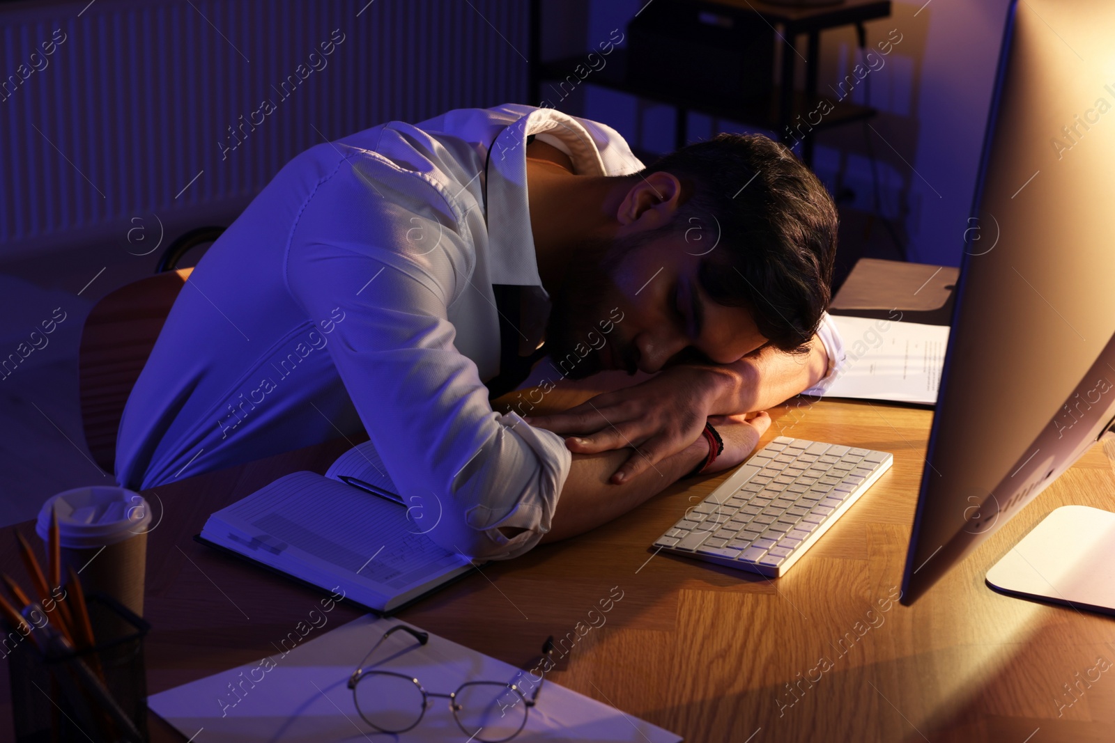 Photo of Tired man fell asleep at workplace in office