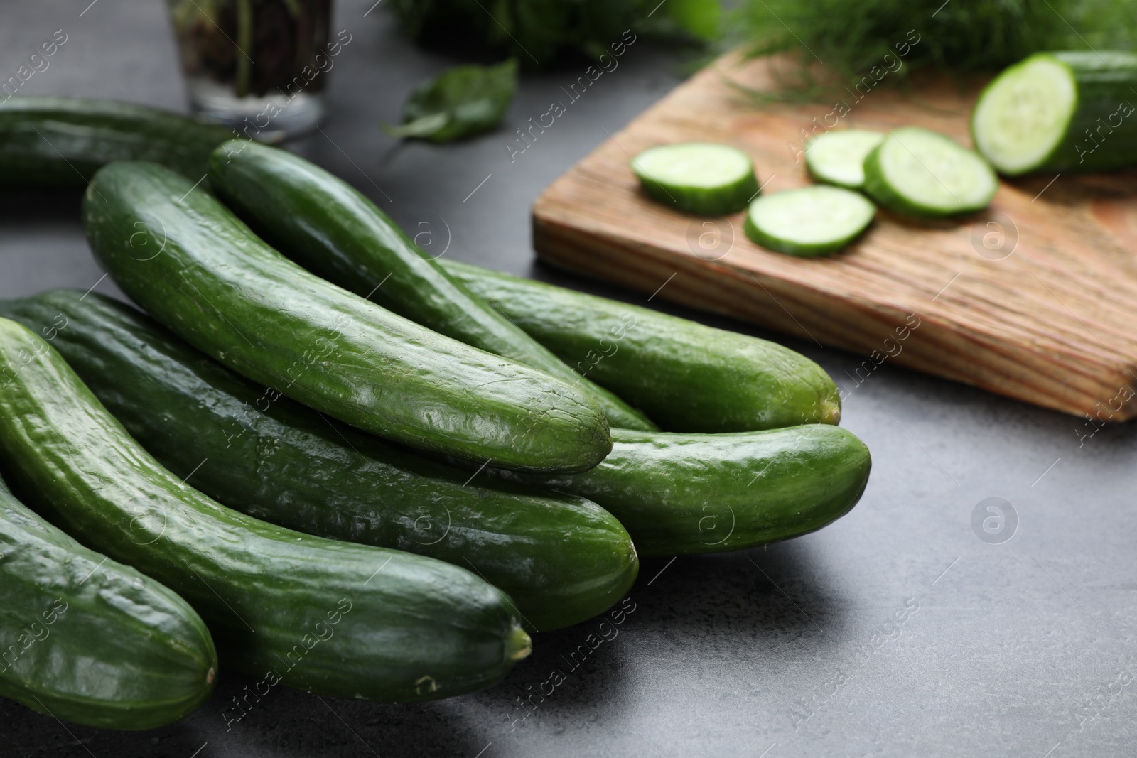 Photo of Fresh ripe cucumbers on grey table, closeup