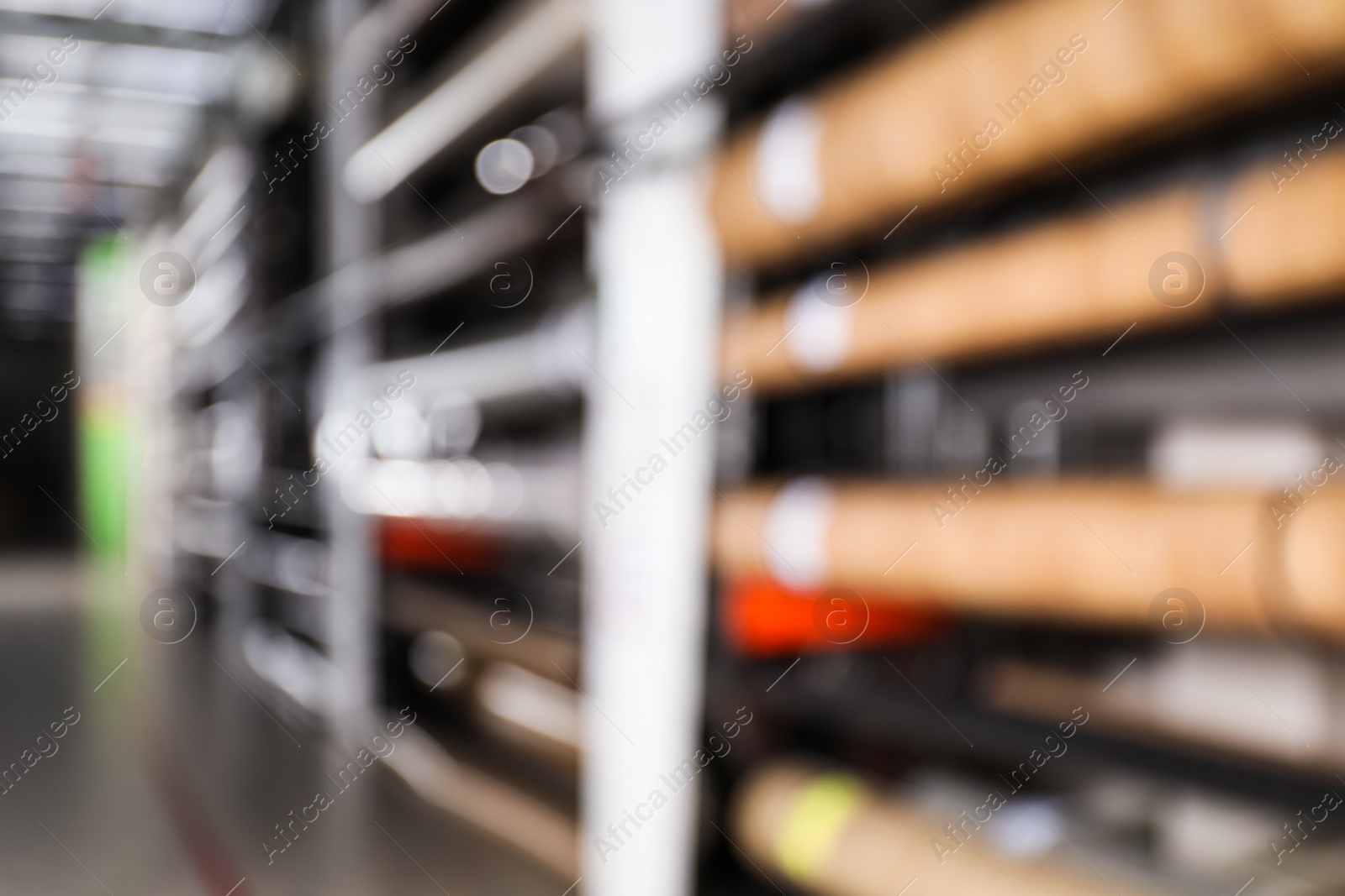 Photo of Blurred view of storage stands with different building materials in wholesale warehouse