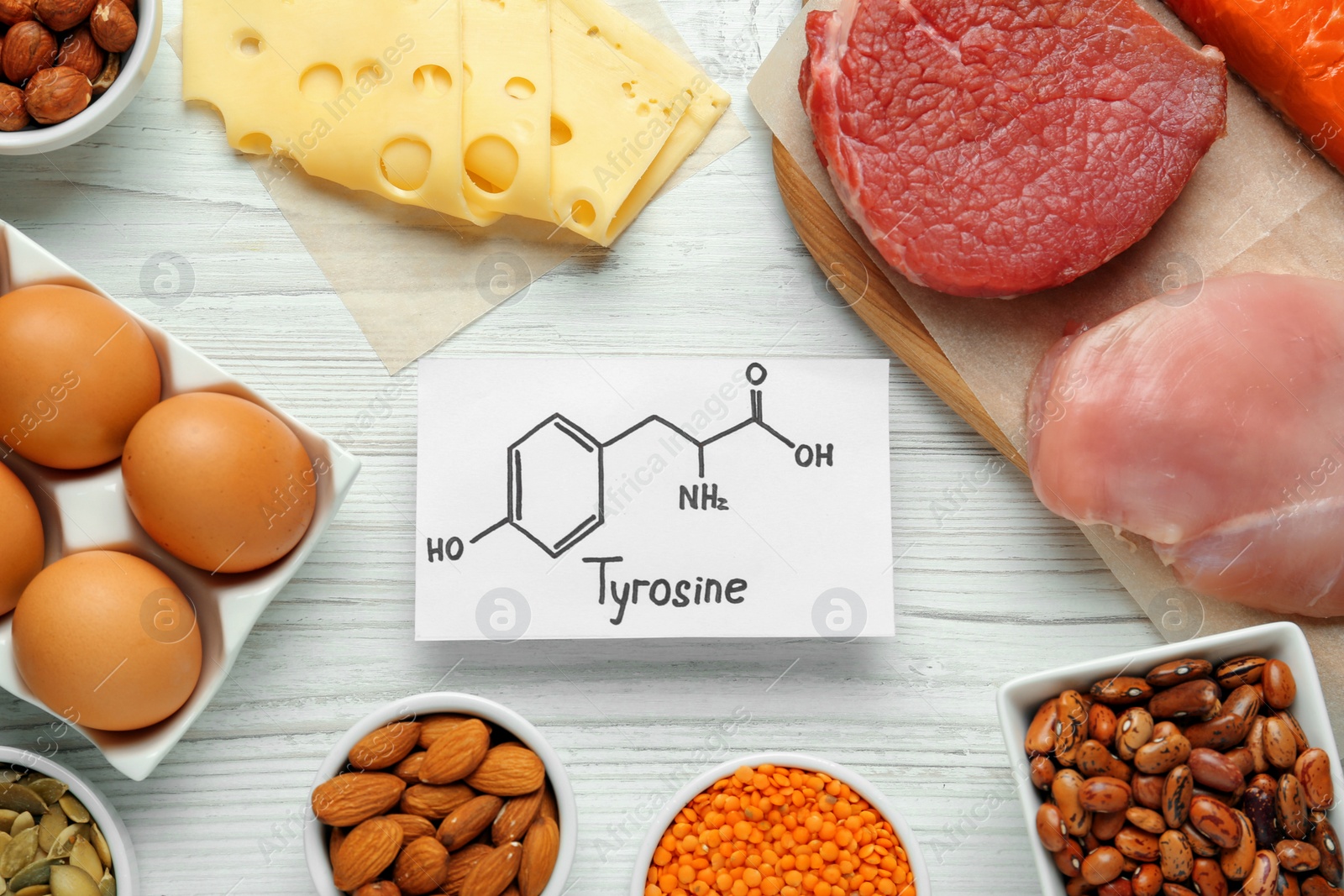 Photo of Different fresh products and paper with Tyrosine chemical formula on white wooden table, flat lay. Sources of essential amino acids