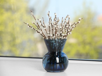 Beautiful pussy willow branches in vase on window sill