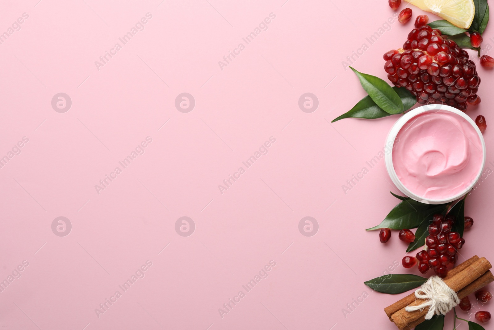 Photo of Flat lay composition with natural homemade mask, pomegranate and ingredients on pink background. Space for text