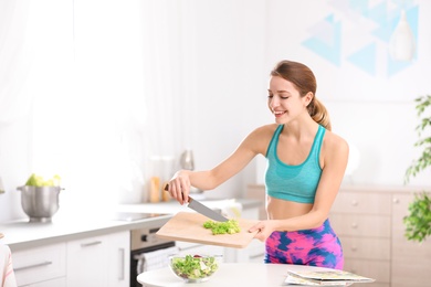 Photo of Young woman in fitness clothes preparing healthy breakfast at home. Space for text