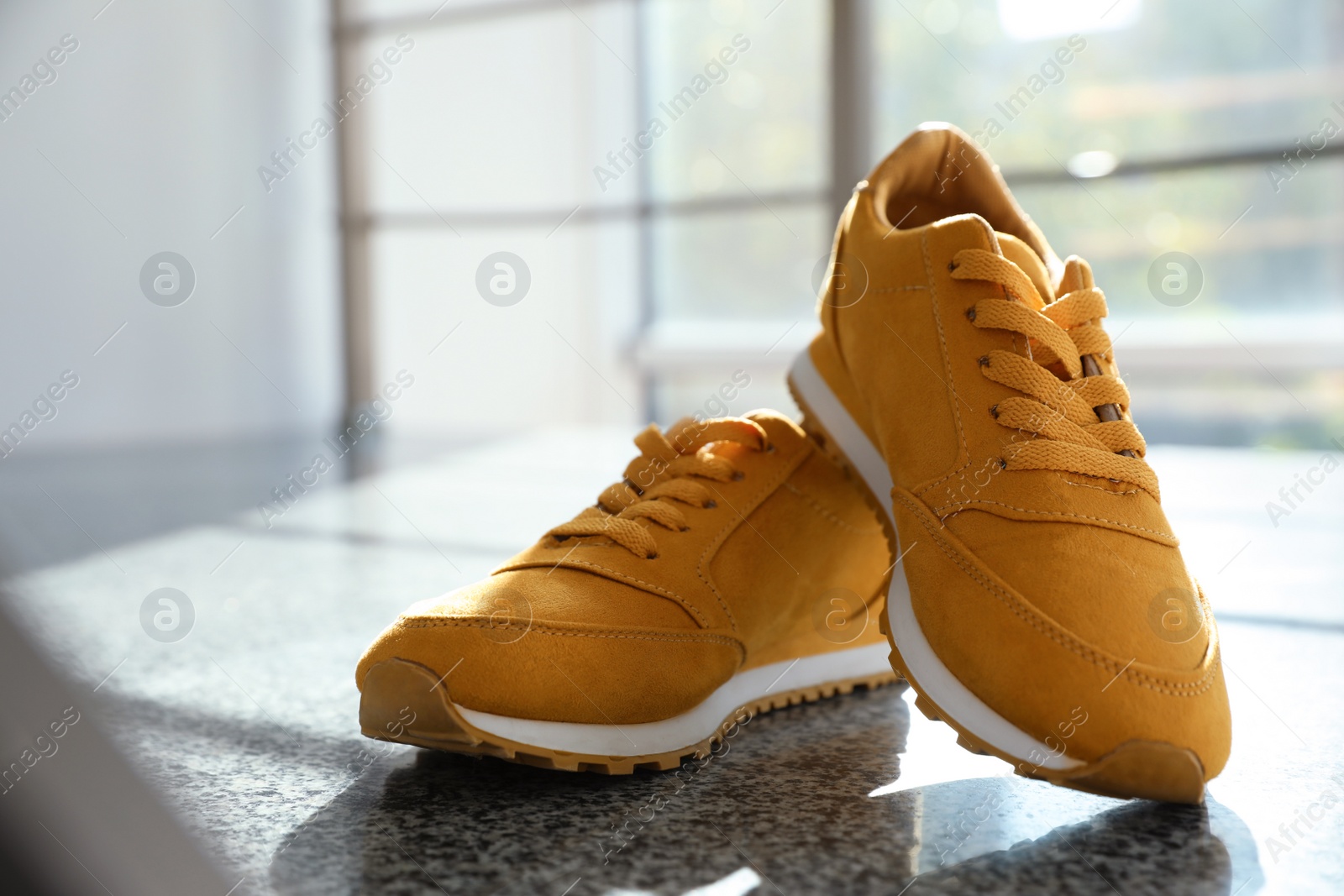 Photo of Pair of stylish women's sneakers on staircase indoors