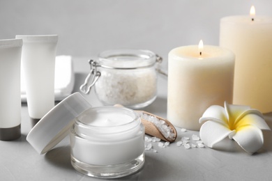 Photo of Composition with cosmetic products and candles on grey table