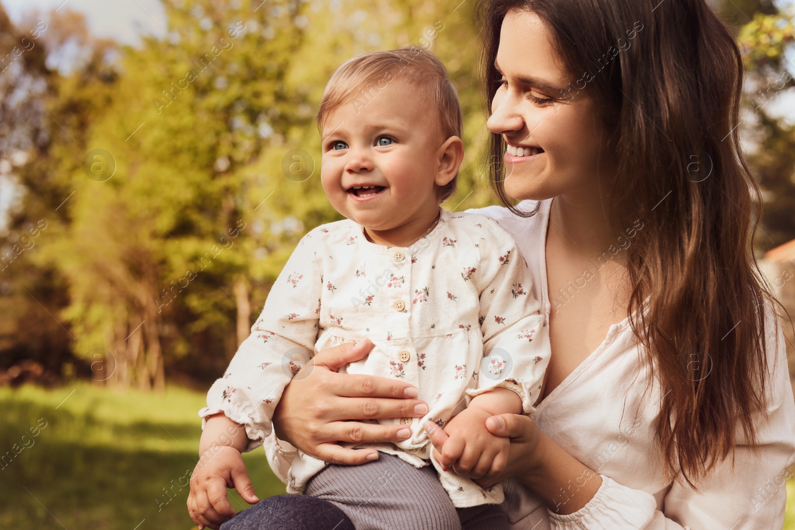 Image of Happy mother with her cute baby in park on sunny day