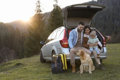 Photo of Parents, their daughter and dog near car in mountains, space for text. Family traveling with pet