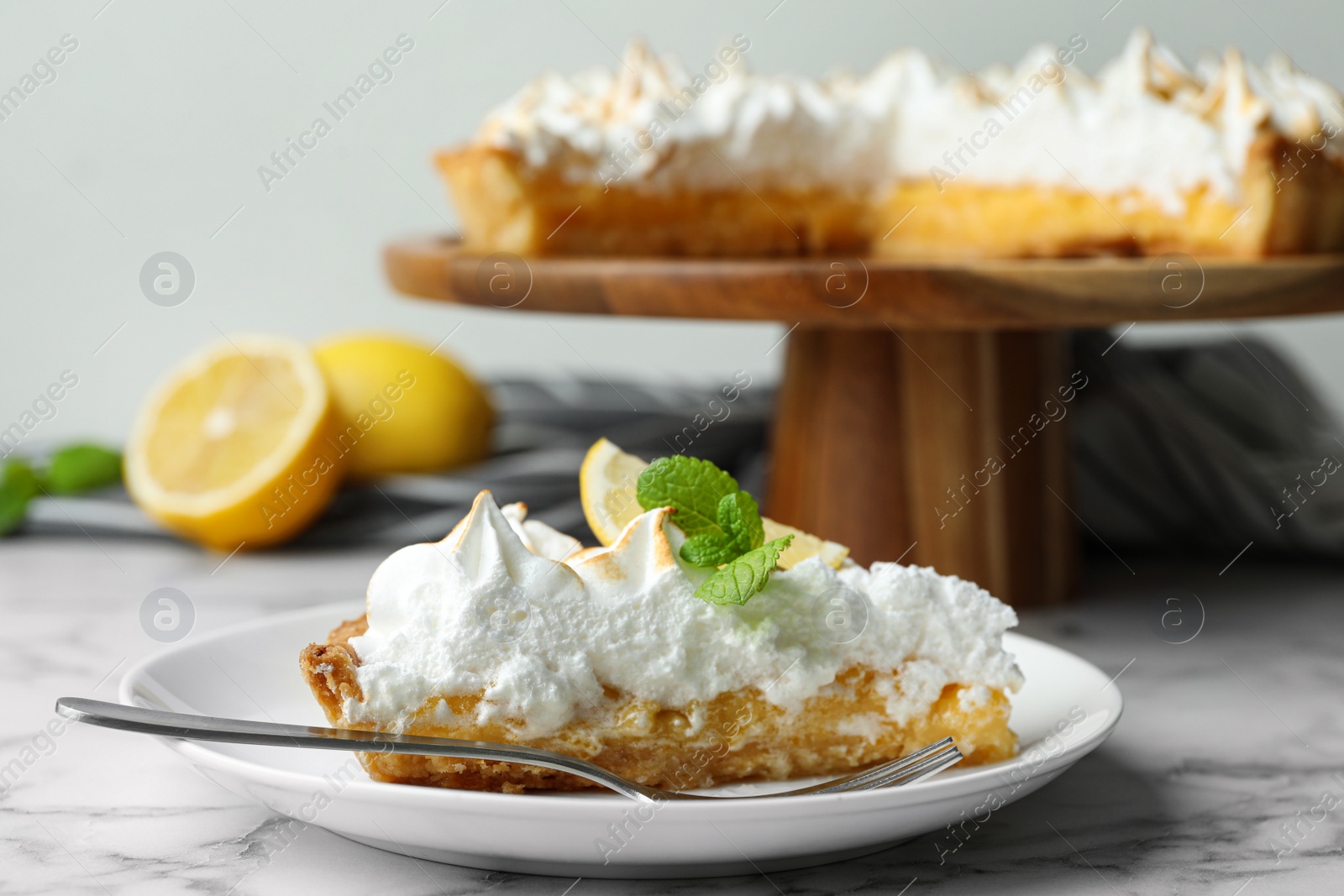 Photo of Delicious lemon meringue pie served on white marble table