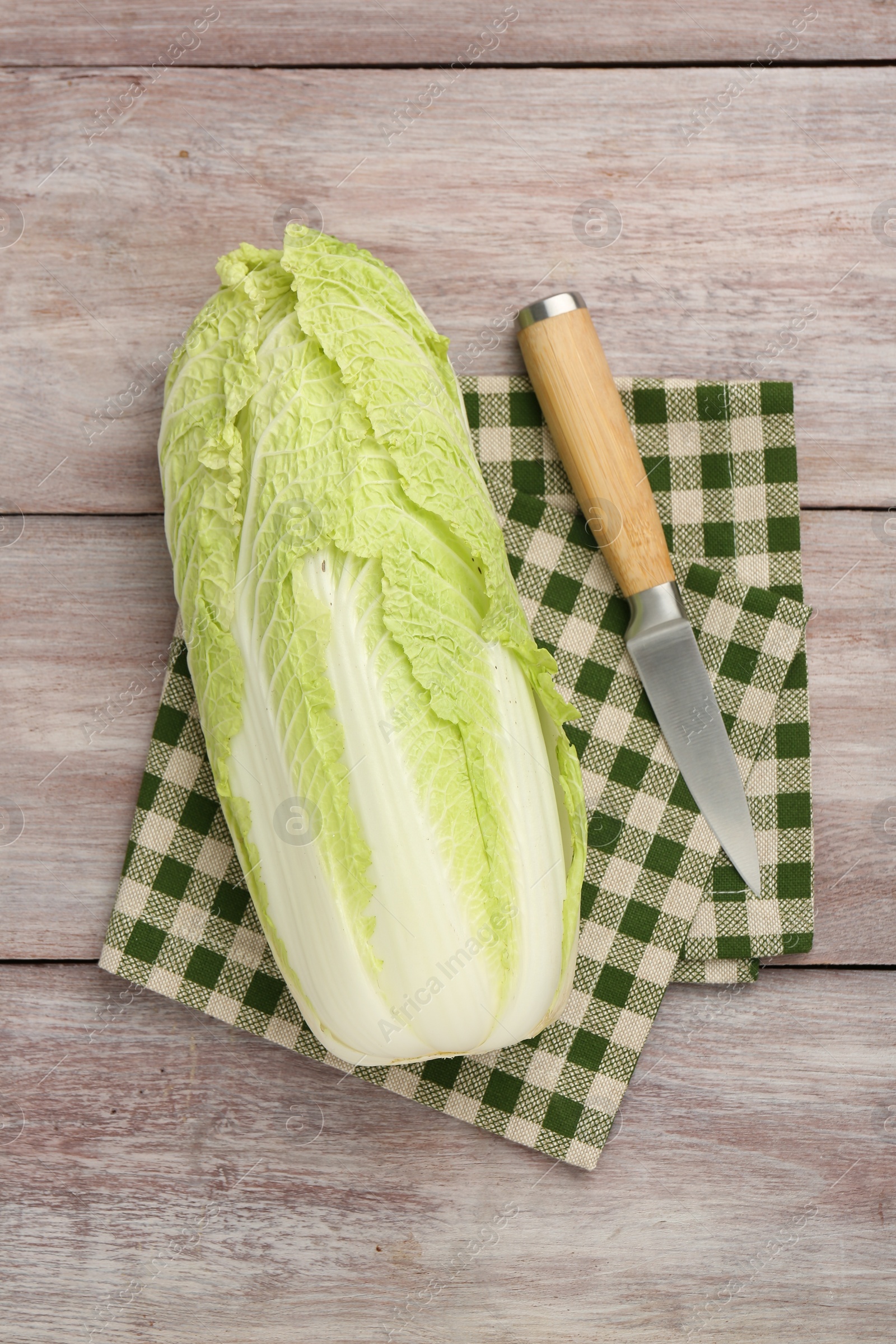 Photo of Fresh ripe Chinese cabbage and knife on wooden table, top view