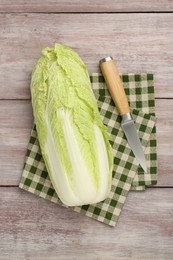 Photo of Fresh ripe Chinese cabbage and knife on wooden table, top view