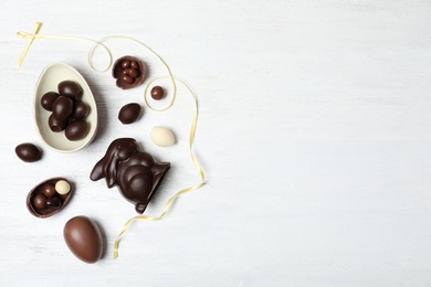 Photo of Flat lay composition with chocolate Easter eggs and space for text on wooden background