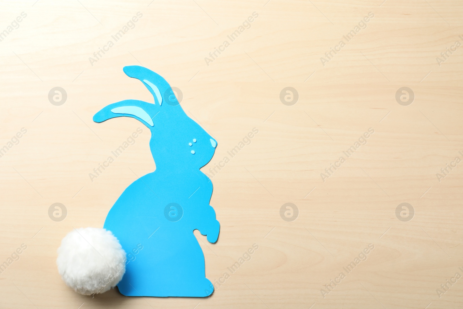 Photo of Flat lay composition of paper Easter bunny on wooden background, space for text