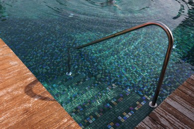 Swimming pool, metal rail and steps at luxury resort