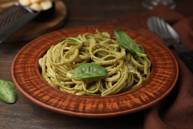 Photo of Tasty pasta with spinach on wooden table, closeup