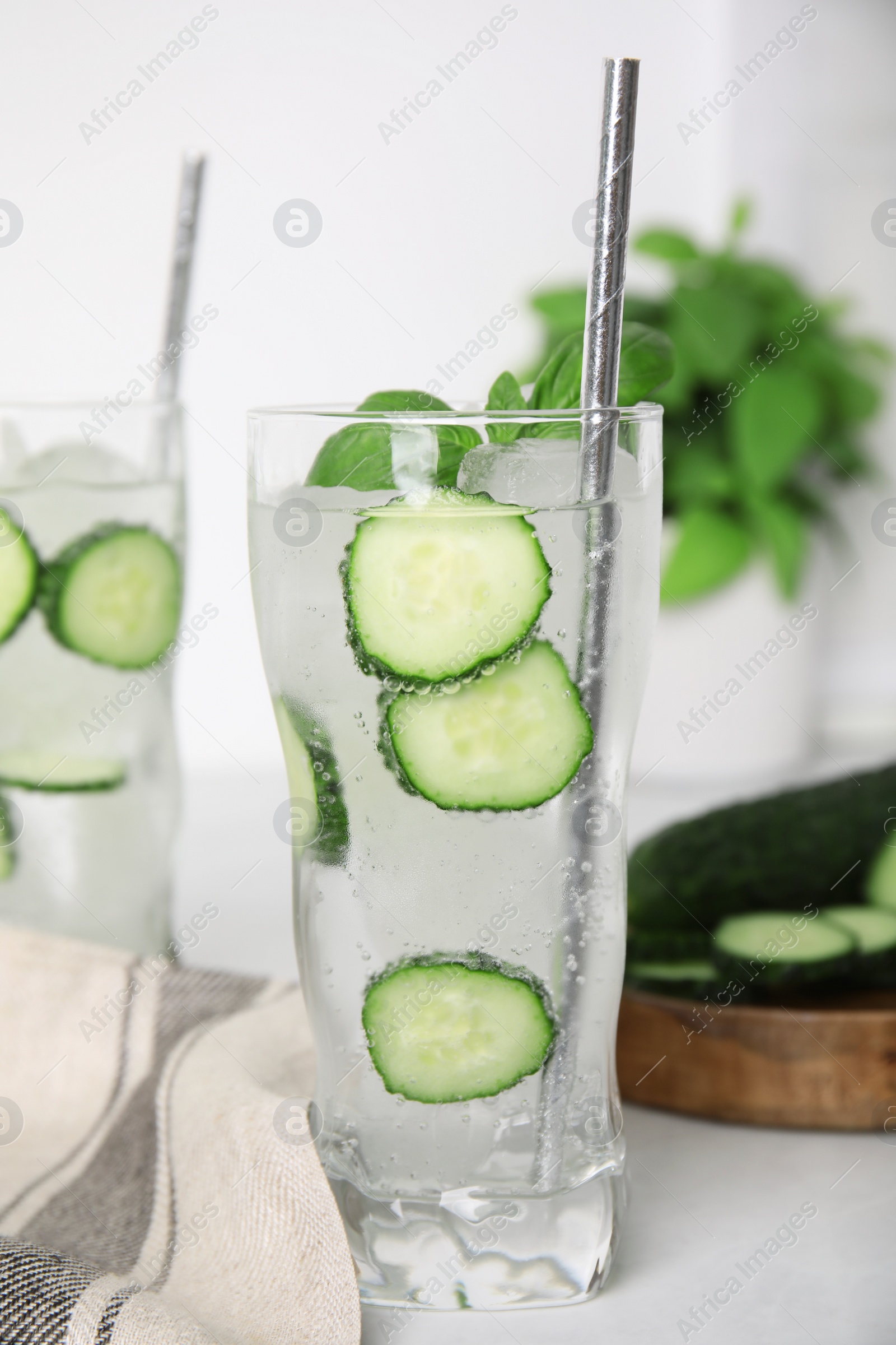 Photo of Tasty fresh cucumber water on white table, closeup