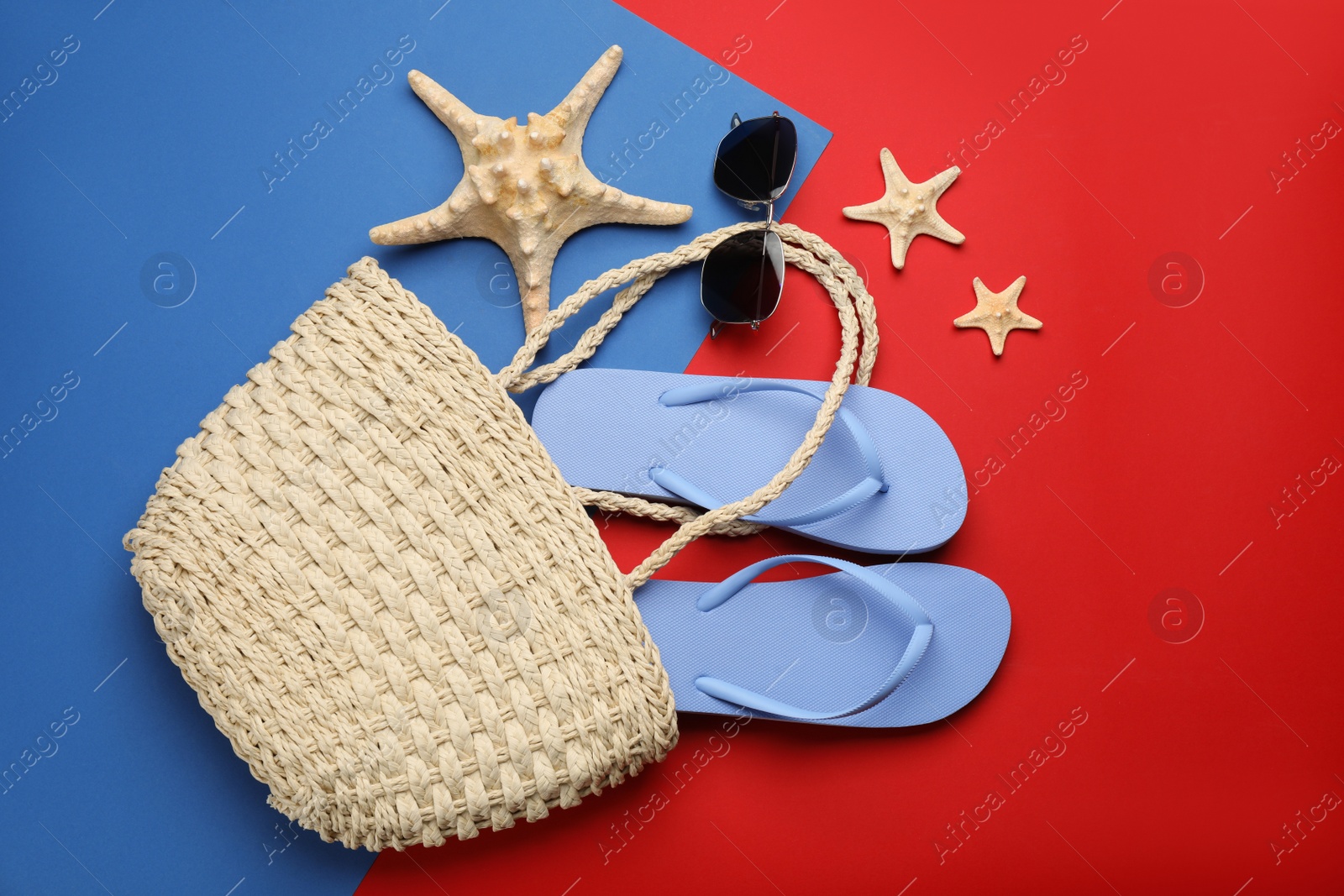 Photo of Stylish bag with beach accessories on color background, flat lay