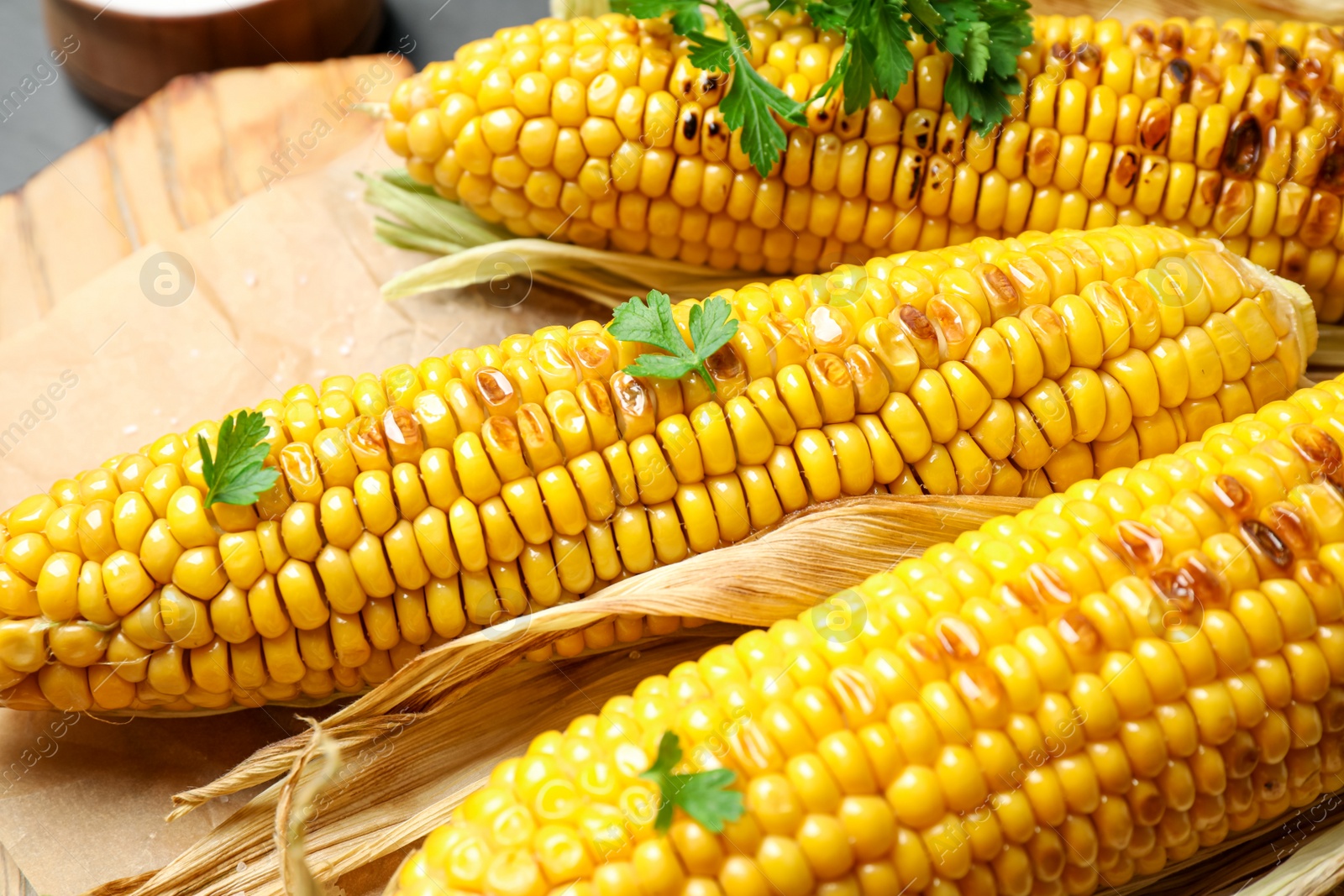 Photo of Tasty grilled corn on table, closeup view
