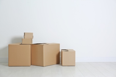 Photo of Cardboard boxes on floor near white wall