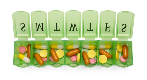 Different pills in organizer isolated on white, top view