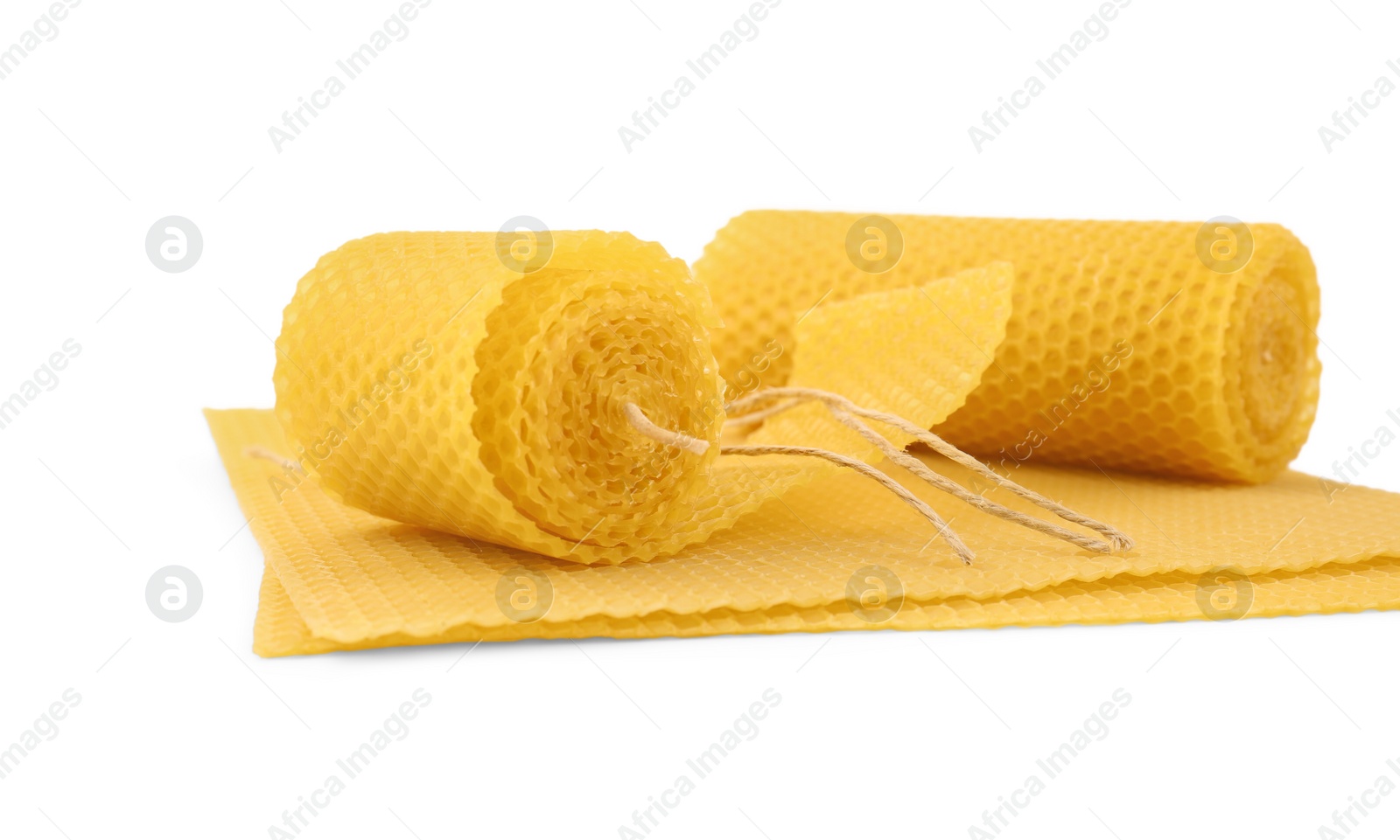 Photo of Stylish elegant beeswax candles and wax sheets isolated on white