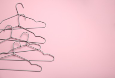 Hangers on pink background, flat lay. Space for text